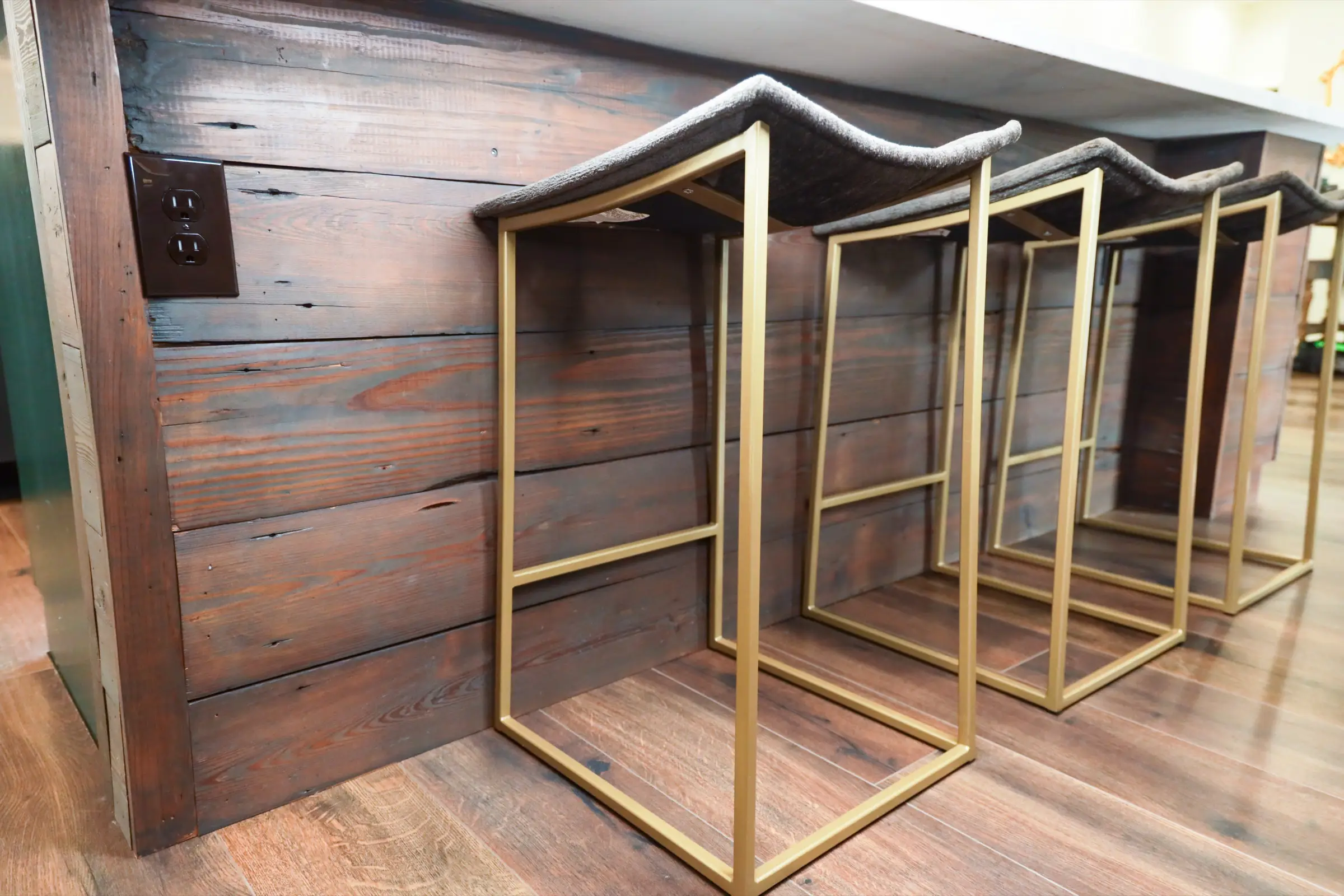 Interior design detail shot of a dark green built-in bar with brass hardware and open wine storage.